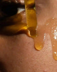 woman applying facial moisturizer oii for acne prone skin, dark marks, & ingrown hairs.