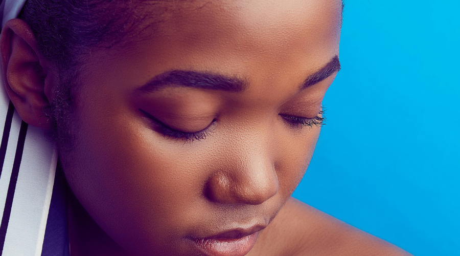 Woman with towel dealing with facial hair on sensitive skin