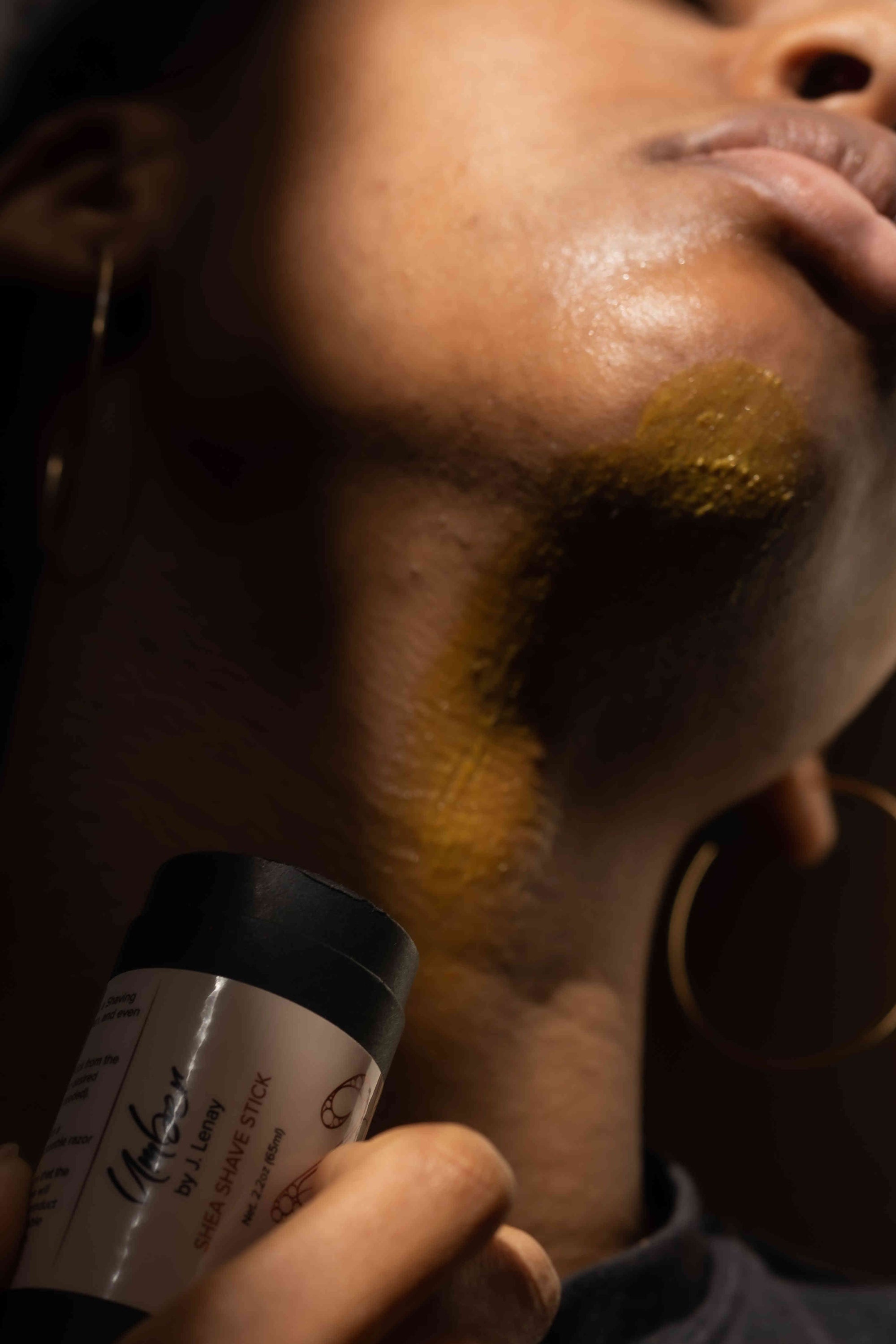 Model applying Shea Shave Stick on neck